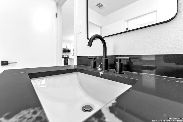 details with visible vents, appliances with stainless steel finishes, and vanity