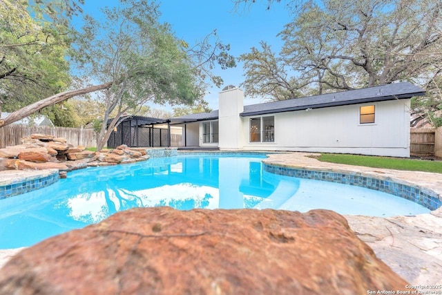 view of swimming pool featuring fence and a fenced in pool