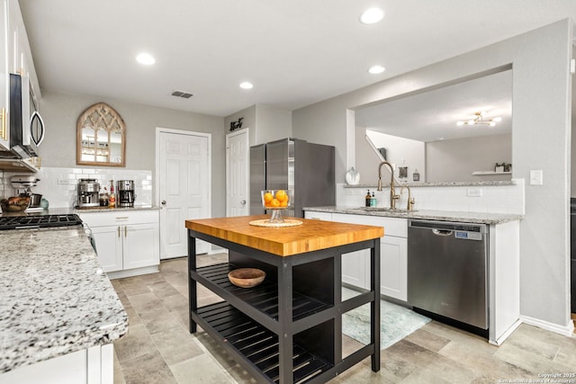 kitchen with recessed lighting, visible vents, appliances with stainless steel finishes, white cabinetry, and a sink