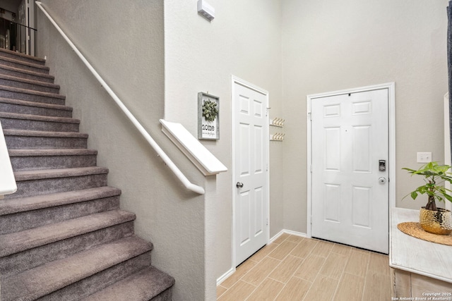 foyer entrance with stairs and wood tiled floor