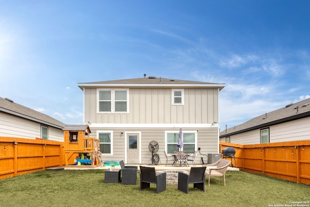 rear view of property with board and batten siding, a fenced backyard, and a patio