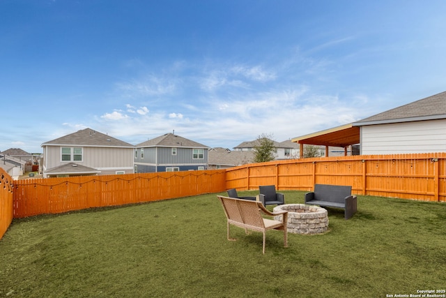 view of yard featuring an outdoor fire pit, a fenced backyard, and a residential view