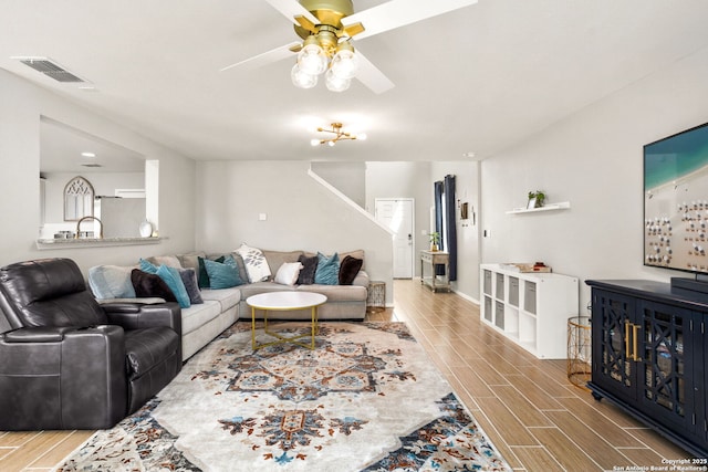 living room featuring wood tiled floor, visible vents, ceiling fan, and baseboards