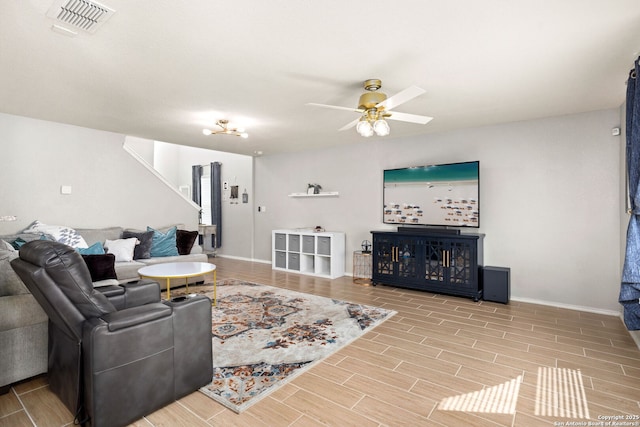 living area featuring baseboards, wood tiled floor, visible vents, and a ceiling fan