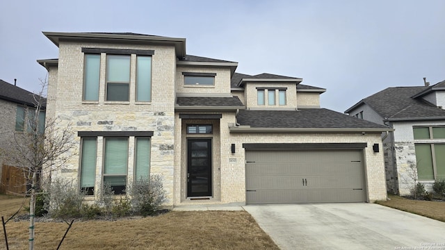 view of front of house featuring a garage, a shingled roof, concrete driveway, stone siding, and brick siding