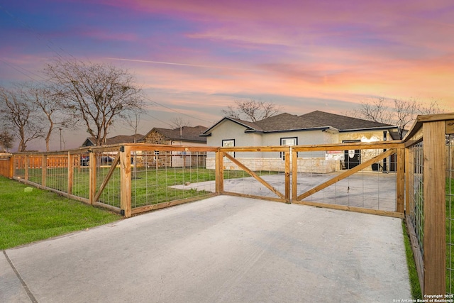 view of gate with a lawn and fence