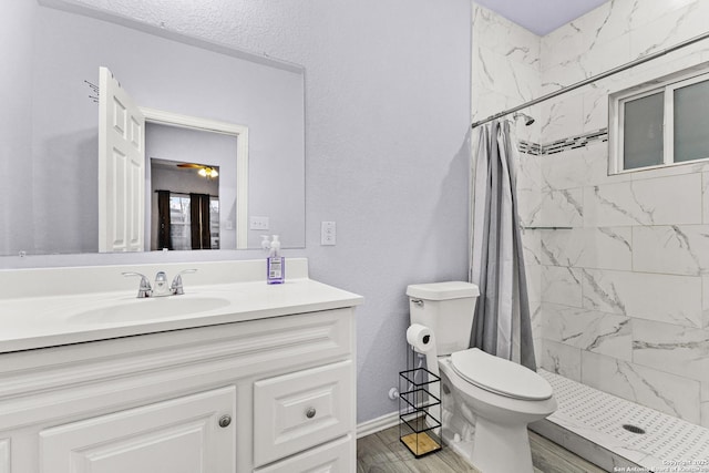 full bath with a stall shower, vanity, toilet, and wood finished floors