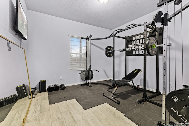 workout area with baseboards and a textured ceiling