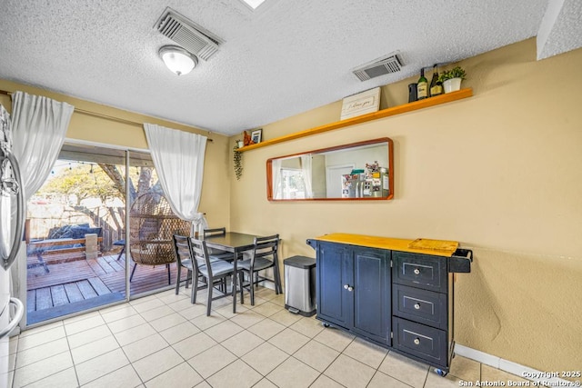 dining space with visible vents, a textured ceiling, and light tile patterned flooring