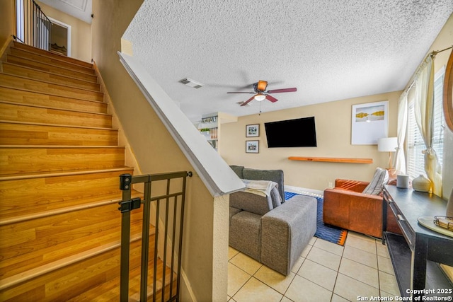 interior space featuring ceiling fan, a textured ceiling, tile patterned flooring, and visible vents