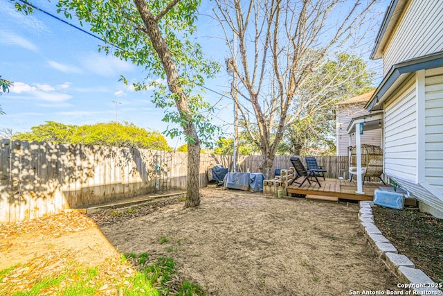 view of yard with a fenced backyard and a wooden deck