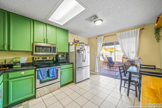 kitchen with dark countertops, visible vents, appliances with stainless steel finishes, and green cabinetry