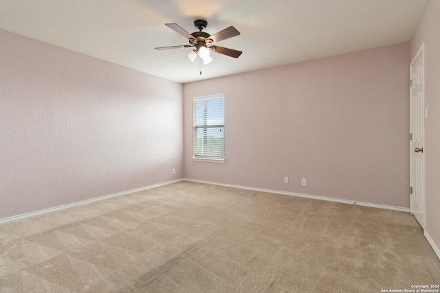 unfurnished room featuring baseboards, a ceiling fan, and light colored carpet