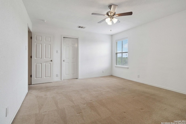 unfurnished bedroom with baseboards, carpet, visible vents, and a ceiling fan