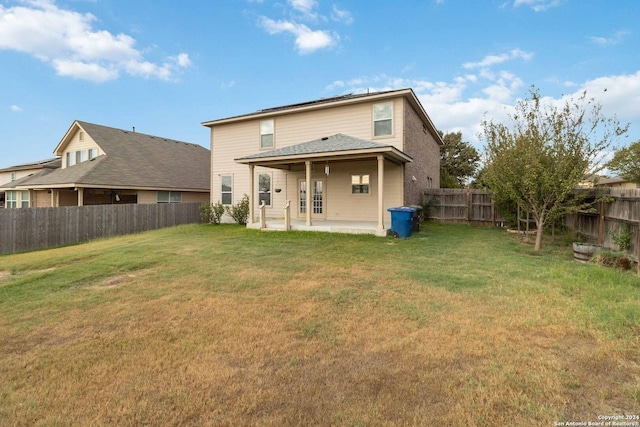 back of house with a yard, a patio area, and a fenced backyard