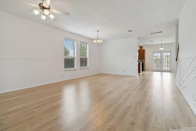 unfurnished room featuring french doors, visible vents, light wood finished floors, and ceiling fan with notable chandelier