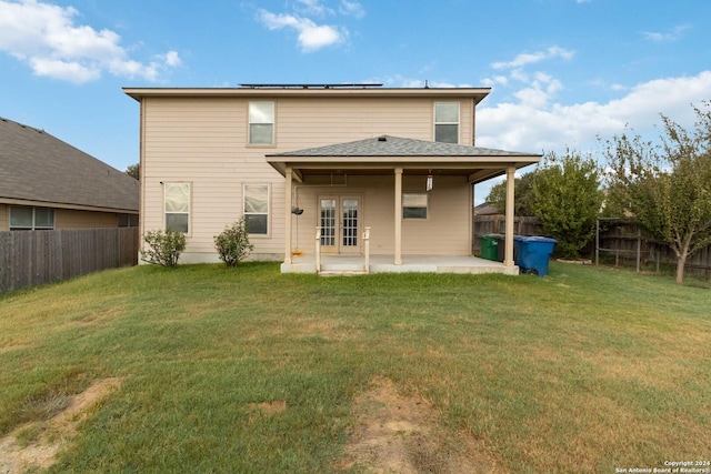 back of property with a patio area, a fenced backyard, a lawn, and french doors