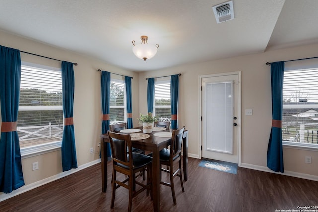 dining area featuring wood finished floors, visible vents, and baseboards