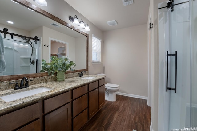 bathroom featuring wood finished floors, a sink, and visible vents