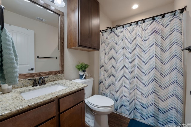 full bath featuring curtained shower, visible vents, toilet, vanity, and wood finished floors