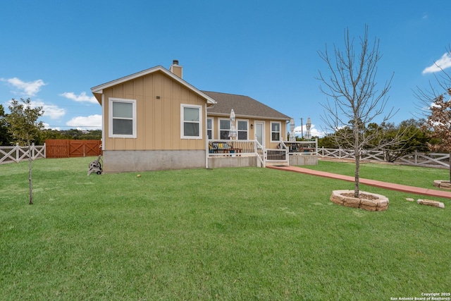 rear view of property with board and batten siding, a fenced backyard, a yard, and a chimney