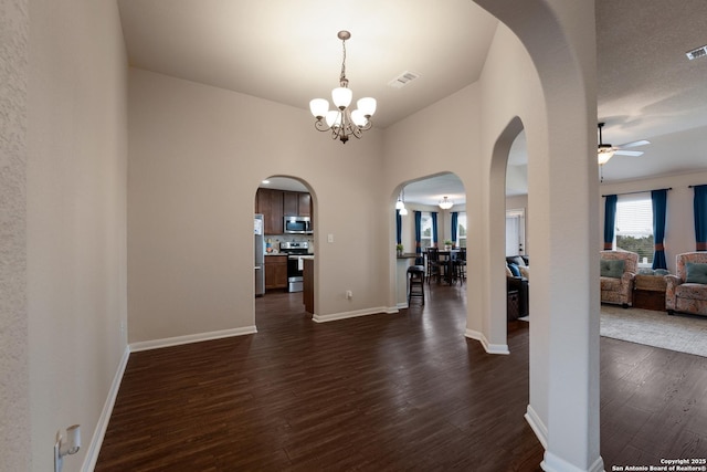 interior space featuring arched walkways, visible vents, dark wood finished floors, and baseboards