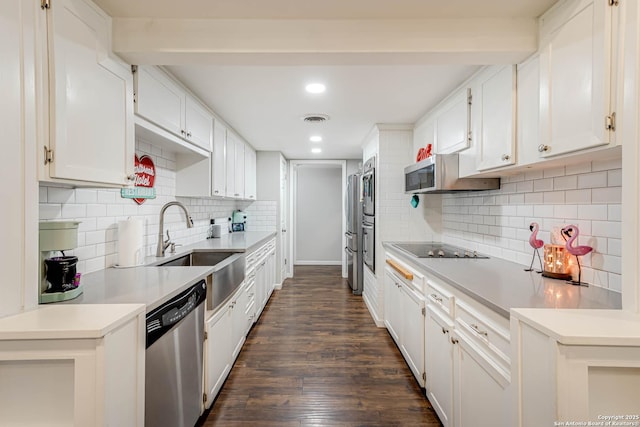 kitchen with stainless steel appliances, a sink, visible vents, white cabinets, and dark wood finished floors