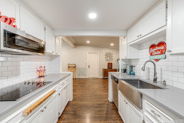 kitchen featuring dark wood-style floors, light countertops, appliances with stainless steel finishes, white cabinets, and a sink