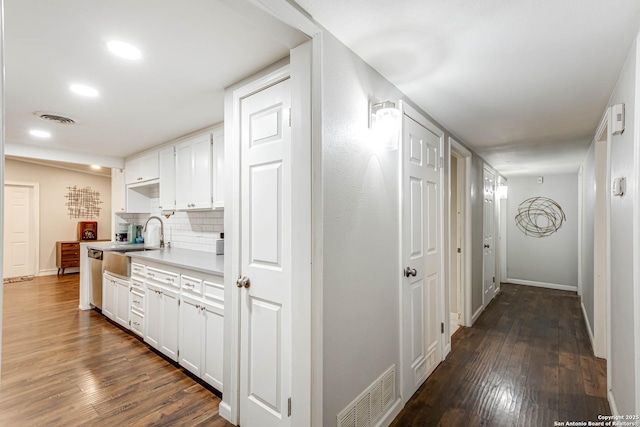 corridor featuring visible vents, dark wood finished floors, and a sink