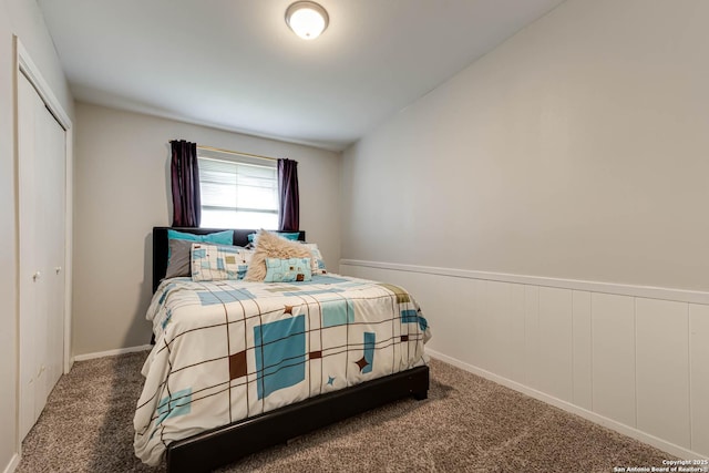 carpeted bedroom featuring a closet and wainscoting