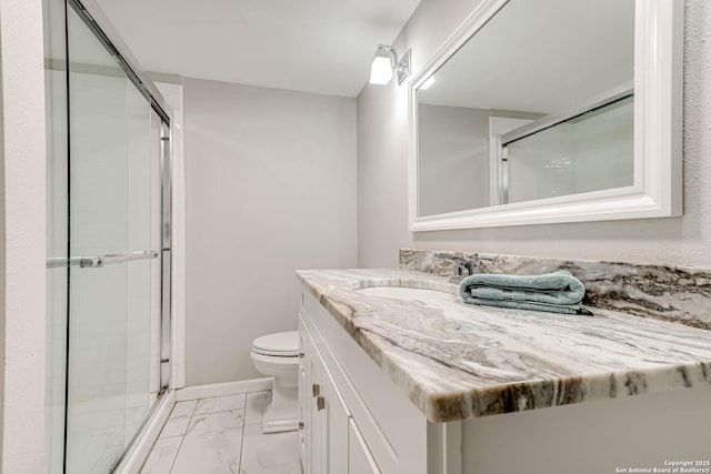 bathroom featuring toilet, marble finish floor, a shower stall, and vanity