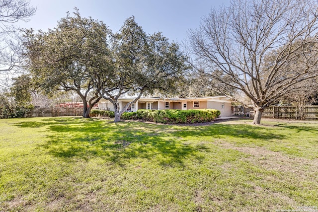 ranch-style house with fence and a front lawn