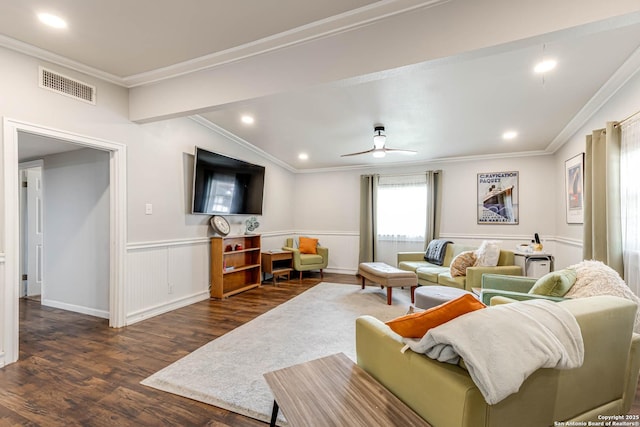 living area with visible vents, dark wood finished floors, wainscoting, ceiling fan, and crown molding