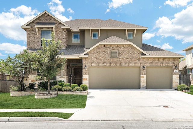 view of front of home with a garage, driveway, a shingled roof, brick siding, and a front yard