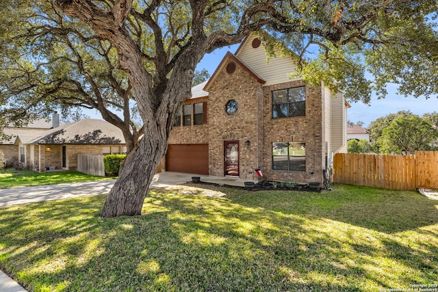 traditional home featuring concrete driveway, brick siding, a front yard, and fence