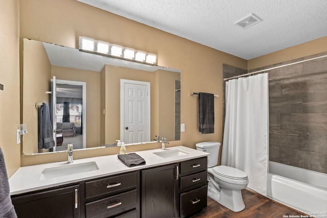 bathroom with toilet, wood finished floors, a sink, and visible vents