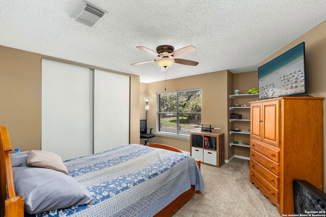 bedroom with light carpet, a closet, visible vents, and a textured ceiling