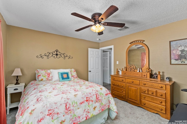 carpeted bedroom with ceiling fan, visible vents, and a textured ceiling