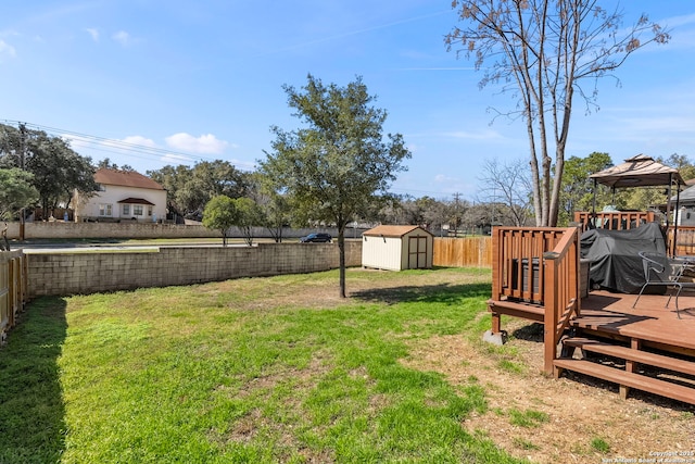 view of yard featuring a storage shed, a fenced backyard, and an outbuilding