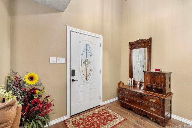 foyer entrance featuring wood finished floors and baseboards