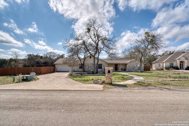 ranch-style house featuring driveway, a front lawn, an attached garage, and fence