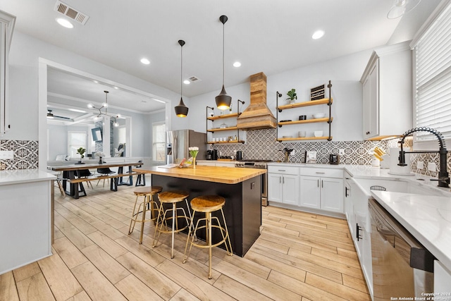 kitchen with stainless steel appliances, butcher block countertops, a center island, wood tiled floor, and custom range hood