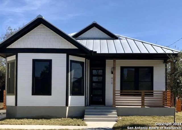 view of front of property featuring metal roof, a porch, and a standing seam roof