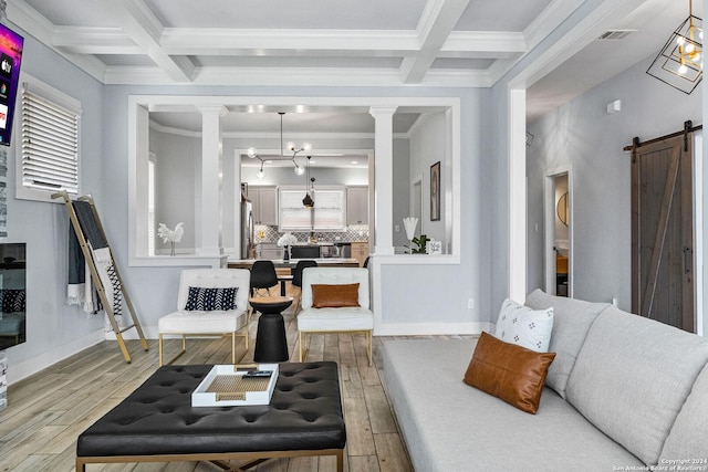 living room with ornate columns, a barn door, coffered ceiling, and wood finished floors