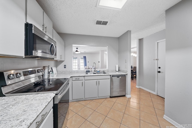 kitchen with light tile patterned floors, visible vents, appliances with stainless steel finishes, light countertops, and a sink