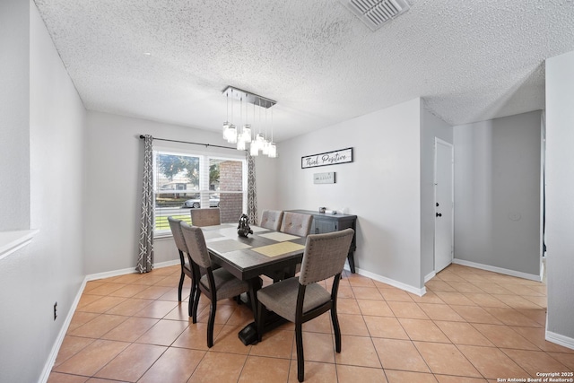 dining area featuring baseboards, visible vents, a notable chandelier, and light tile patterned flooring