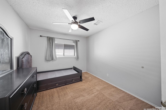 unfurnished bedroom featuring a textured ceiling, carpet, a ceiling fan, and baseboards