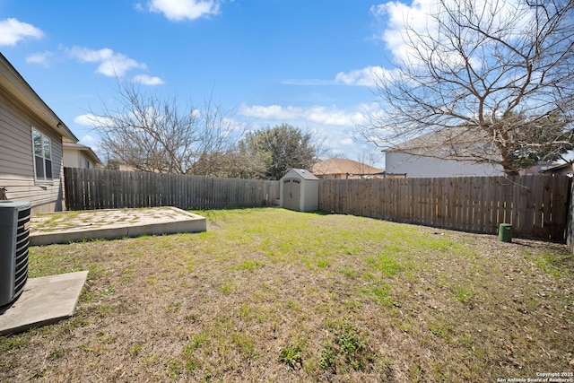 view of yard with a shed, an outdoor structure, a fenced backyard, and cooling unit