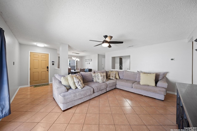 living area with ceiling fan with notable chandelier, a textured ceiling, baseboards, and light tile patterned floors