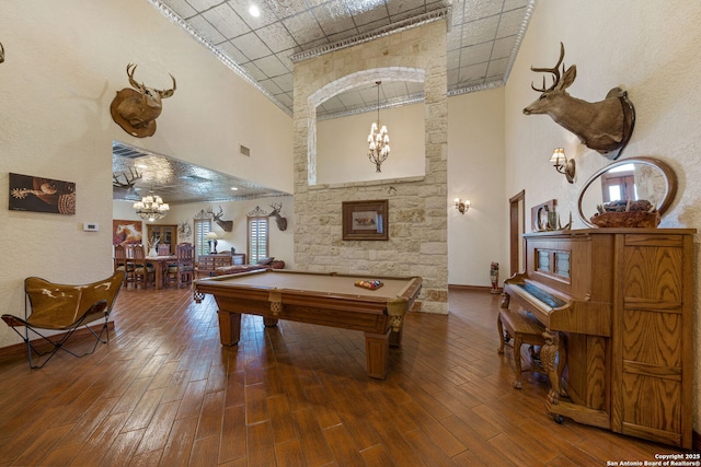 playroom with pool table, a notable chandelier, a high ceiling, and wood finished floors